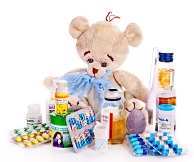 Teddy bear surrounded by children's medications