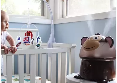 Baby in crib looking at monkey shaped humidifier